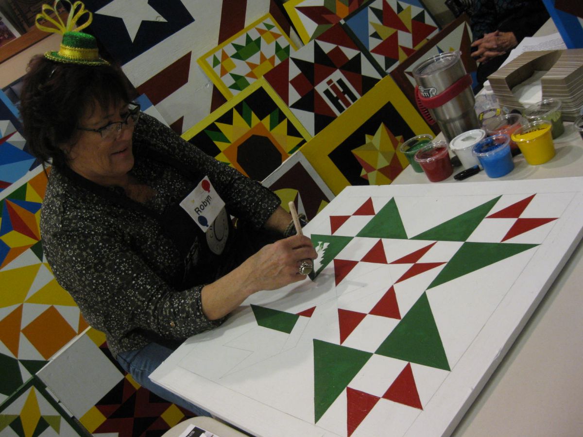 Demonstrator Robyn Hargan paints a section of her latest barn quilt without even taping off the lines!
